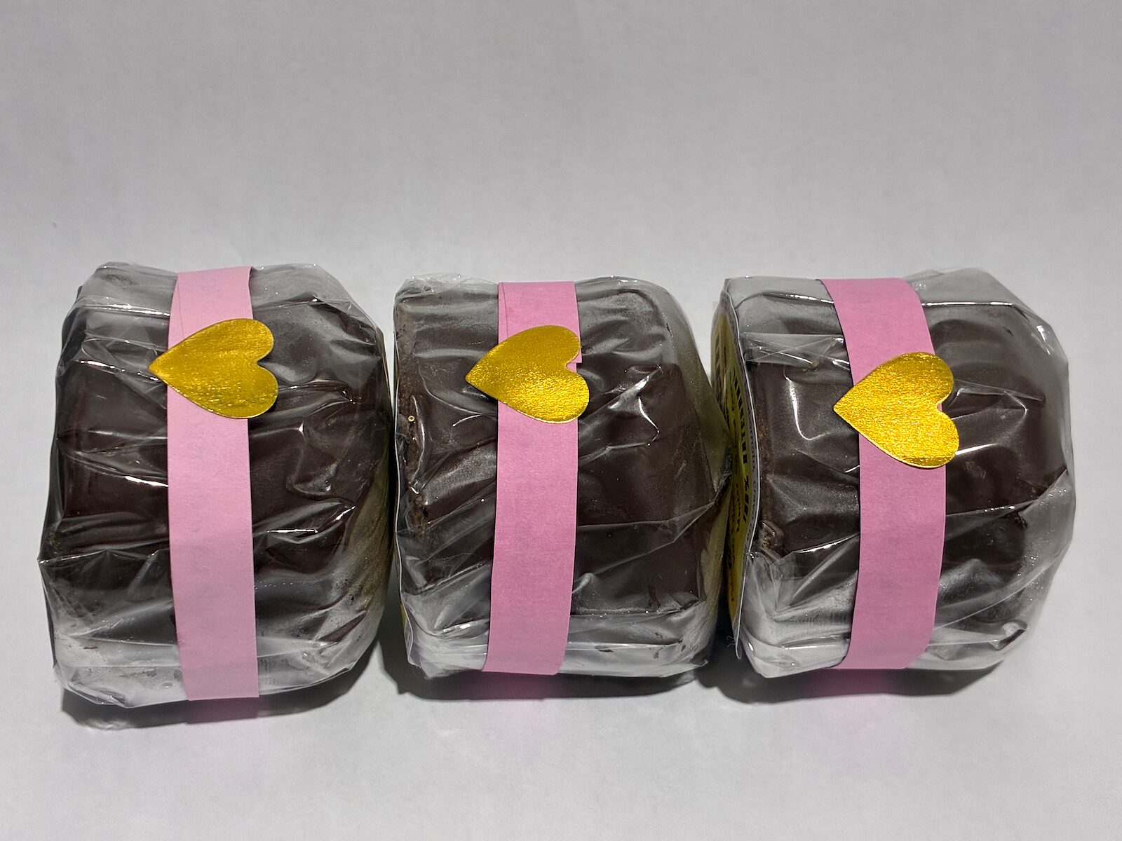 Pães de mel embalados com fita rosa e coração dourado